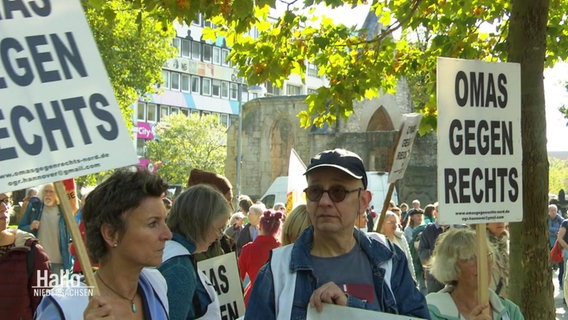 Protestierende Menschen halten Schilder mit der Aufschrift: "Omas gegen Rechts" © Screenshot 