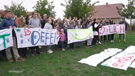 Protestierende Menschen halten Banner mit den Aufschriften: "Offen, Tolerant, Herzlich" © Screenshot 
