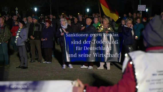 Archivbild: Menschen demonstrieren gegen die Russland-Sanktionen. © Screenshot 