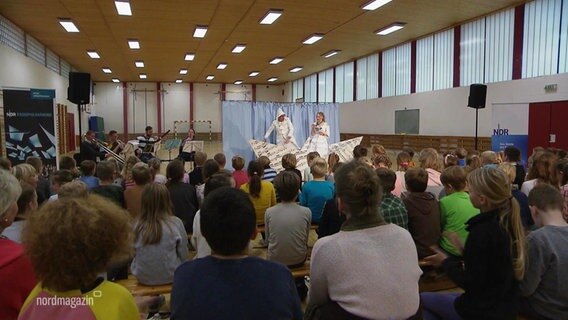 Schülerinnen und Schüler verfolgen das musikalische Theaterstück. © Screenshot 