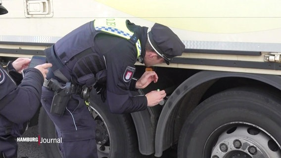Polizeibeamte untersuchen einen Lastwagen. © Screenshot 