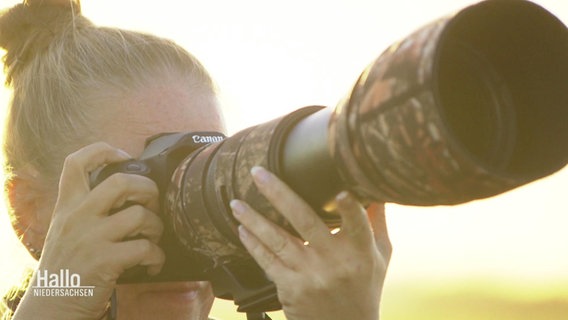 Eine Frau mit einem Fotoapparat. © Screenshot 