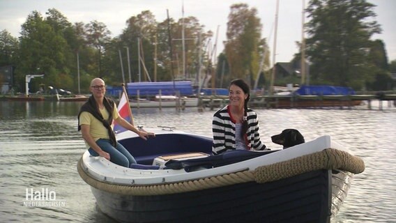 Ein Paar fährt mit ihrem Hund auf einem Boot. © Screenshot 