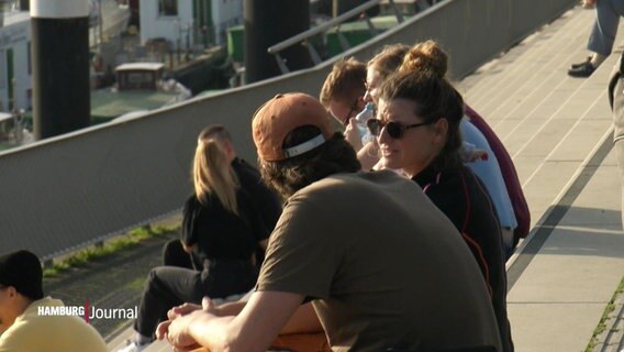 Menschen auf einer Treppe in der Sonne. © Screenshot 