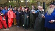 Fischer Piehl und die Frauen, die beim Abfischen geholfen haben, stoßen beim Fischerfest in Alt Schlagsdorf mit einem Getränk an. © Screenshot 