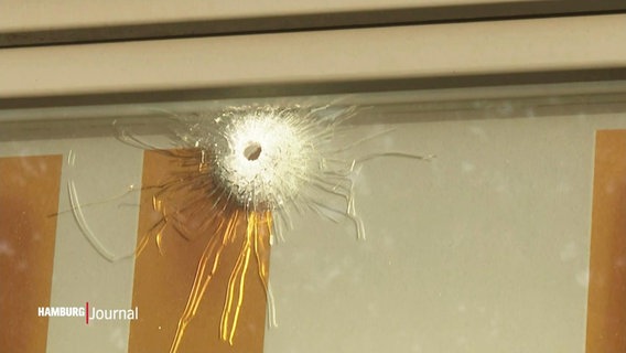 Nahaufnahme von einem Einschussloch in einer Fensterscheibe. © Screenshot 
