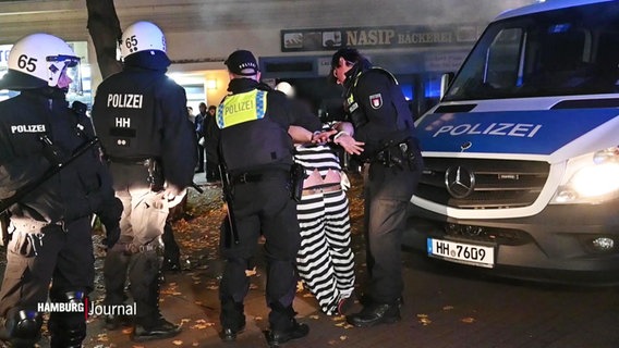 Randalierer werden von der Polizei festgehalten. © Screenshot 