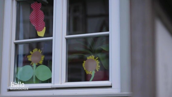 Das Fenster einer Kita mit Papierblumen an der Scheibe. © Screenshot 
