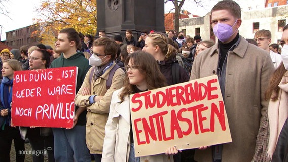 demonstrierende Menschen halten Schilder mit der Aufschrift: "Bildung ist weder Ware noch Privileg" und "Studierende Entlasten" © Screenshot 
