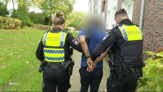 Polizisten führen einen Mann ab. © Screenshot 