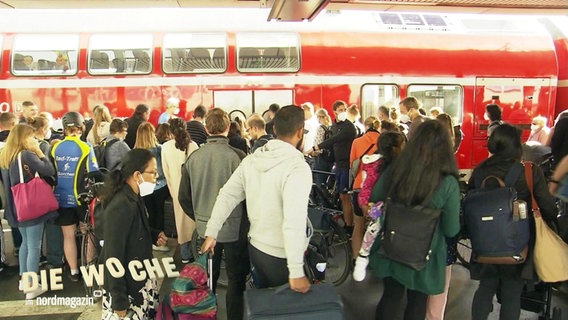 Dutzende Reisende warten vor einem Regionalzug. © Screenshot 