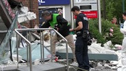 Polizei in den Trümmern der gesprengten Bank © Screenshot 