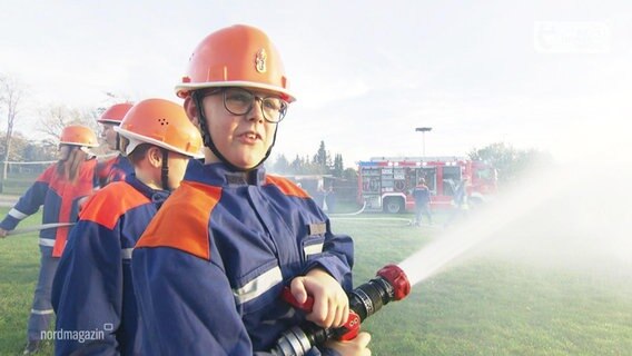 Ein Junge macht einen Schnupperkurs bei der Feuerwehr. © Screenshot 
