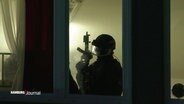 Die Silhouette eines bewaffneten SEK-Mitarbeiters an einem Fenster. © Screenshot 