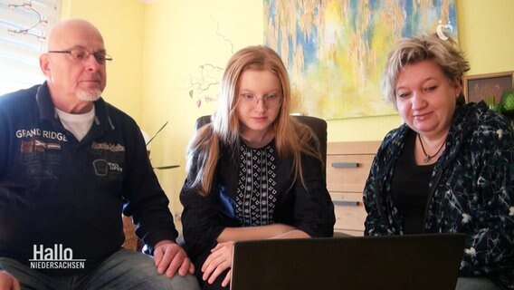 Mona und ihre Eltern sitzen vor einem Laptop © Screenshot 
