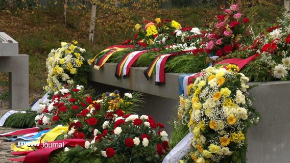 Blumenkränze auf einem Grab. © Screenshot 