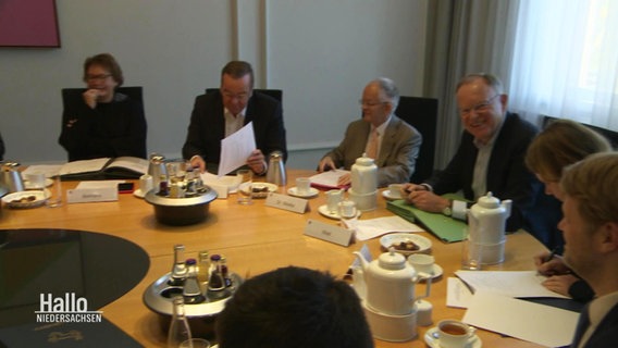Mehrere Politiker und Politikerinnen sitzen um einen Tisch. © Screenshot 