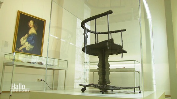 Foltergeräte in Glaskästen stehen in der Ausstellung Hexenwahn. © Screenshot 