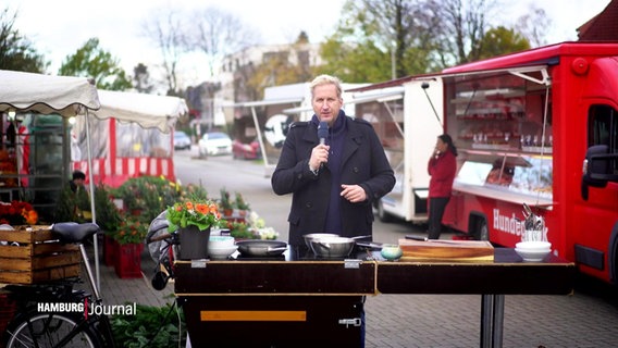Moderator und Koch, Dave Hänsel, an einem mobilen Kochstudio auf dem Fuhlsbütteler Marktplatz © Screenshot 