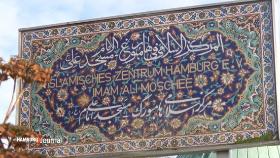 Ein Schild mit der Aufschrift "Islamisches Zentrum Hamburg e.V. - Iman Ali Moschee" steht vor blauem Himmel. © Screenshot 