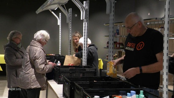 Mitarbeitende der Harbuger Tafel sortieren Lebensmittel. © Screenshot 