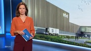 Moderatorin Romy Hiller steht ein einem NDR Studio vor dem Bild einer Fabrikhalle. © Screenshot 