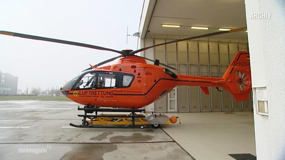 Ein orangener Hubschrauber fährt aus der Garage. © Screenshot 