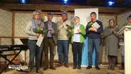 Fünf der sechs Preisträger*innen stehen auf einer Bühne und haben ihren Preis vom "Ferteel Iinjsen" 2022 entgegengenommen. © Screenshot 