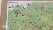 Nahaufnahme einer Landkarte von Niedersachsen. In ihr stecken rote und schwarze Stecknadeln. © Screenshot 