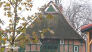 Ein altes renoviertes Fachwerkhaus mit Reetdach. © Screenshot 