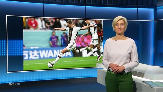 Moderatorin Susanne Stichler, hinter ihr ein Bild aus dem WM-Fußballspiel Deutschland gegen Spanien mit Niclas Füllkrug am Schuss. © Screenshot 