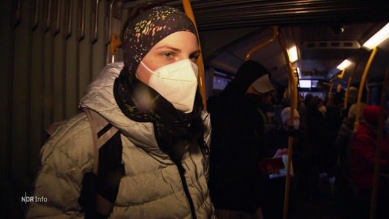 Eine Frau trägt in einem Bus eine Maske. © Screenshot 