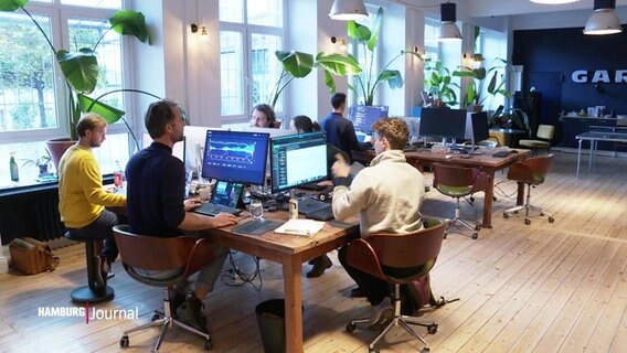 Die Gründer des Start-Ups "Suena" sitzen gesammelt um einen geteiltet Schreibtisch. © Screenshot 