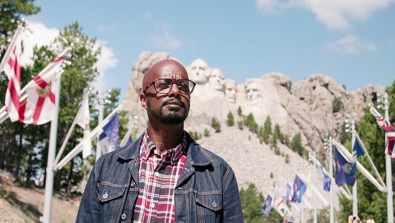 Yared Dibaba steht vor dem Mount Rushmore National Memorial in den USA. © Screenshot 