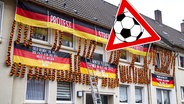 Ein mit Deutschland-Fahnen und Katar-Protest behängtes Wohngebäude. © NDR 