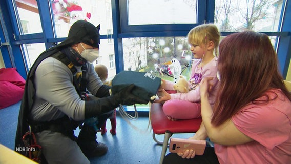 Ein Höhenretter im Batman Kostüm übergibt Geschenke an Kinder © Screenshot 