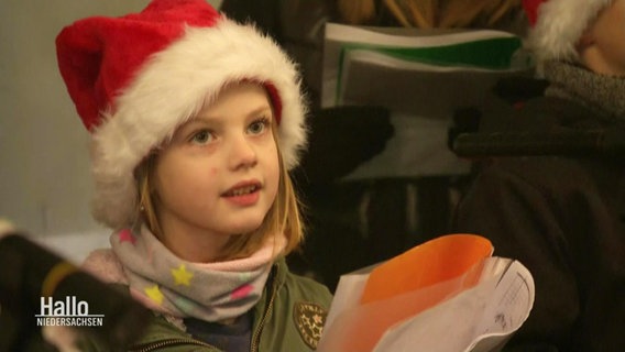 Ein junges Mädchen mit Weihnachtsmann-Mütze © Screenshot 
