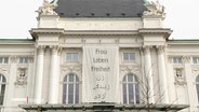 Das Schauspielhaus Hamburg mit einem Banner, auf dem steht: Frau Leben Freiheit. Darunter derselbe Text nochmals in arabischer Schrift. © Screenshot 