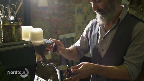 Ein Mann an einer Barrista-Maschine. © Screenshot 