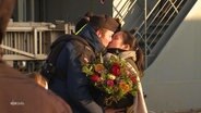 Ein Marinesoldat und eine Frau küssen sich vor einem Schiff. © Screenshot 