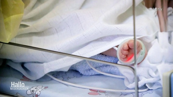 Nahaufnahme eines Kinderfuß der aus einem Krankenhausbett schaut. © Screenshot 