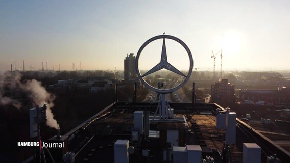 Ein riesiger Mercedes-Stern steht auf einem Dach. © Screenshot 