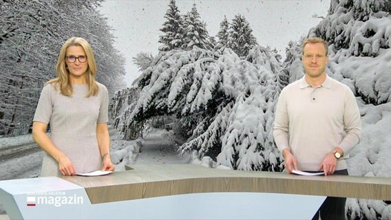 Gabi Lüeßen und Henrik Hanses moderieren das Schleswig-Holstein Magazin um 19:30 Uhr. Beide sind in Grau- und Beigetönen gekleidet. Das Foto im Hintergrund zeigt eine verschneite Winterlandschaft. © Screenshot 