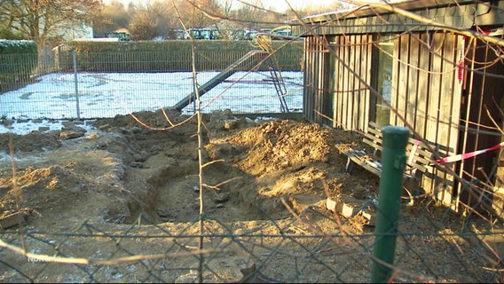 Das Foto zeigt den Leichenfundort: Eine Grube hinter einem Carport. © Screenshot 