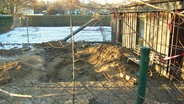 Das Foto zeigt den Leichenfundort: Eine Grube hinter einem Carport. © Screenshot 