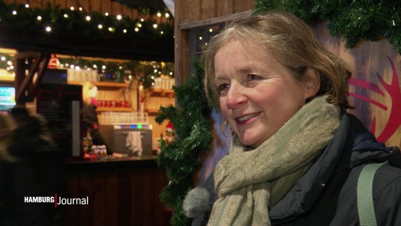 Eine Frau auf einem Weihnachtsmarkt spricht in die Kamera. © Screenshot 