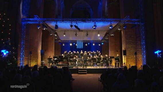 Die NDR BigBand bei einem Auftritt auf einer Bühne in einer Kirche. © Screenshot 
