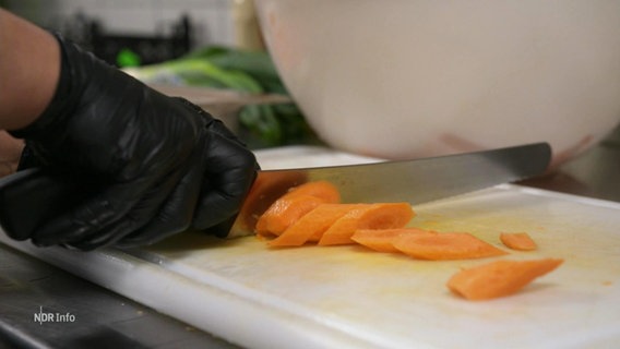 Ein Schneidebrett auf dem eine Karotte geschnitten wird © Screenshot 