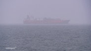 Hinter Nebelschwaden erkennt man auf dem Meer ein großes Tankschiff. © Screenshot 