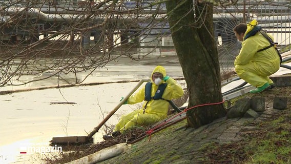 zwei Personen, in Schutzanzügen arbeiten an der Reinigung des Kanals © Screenshot 